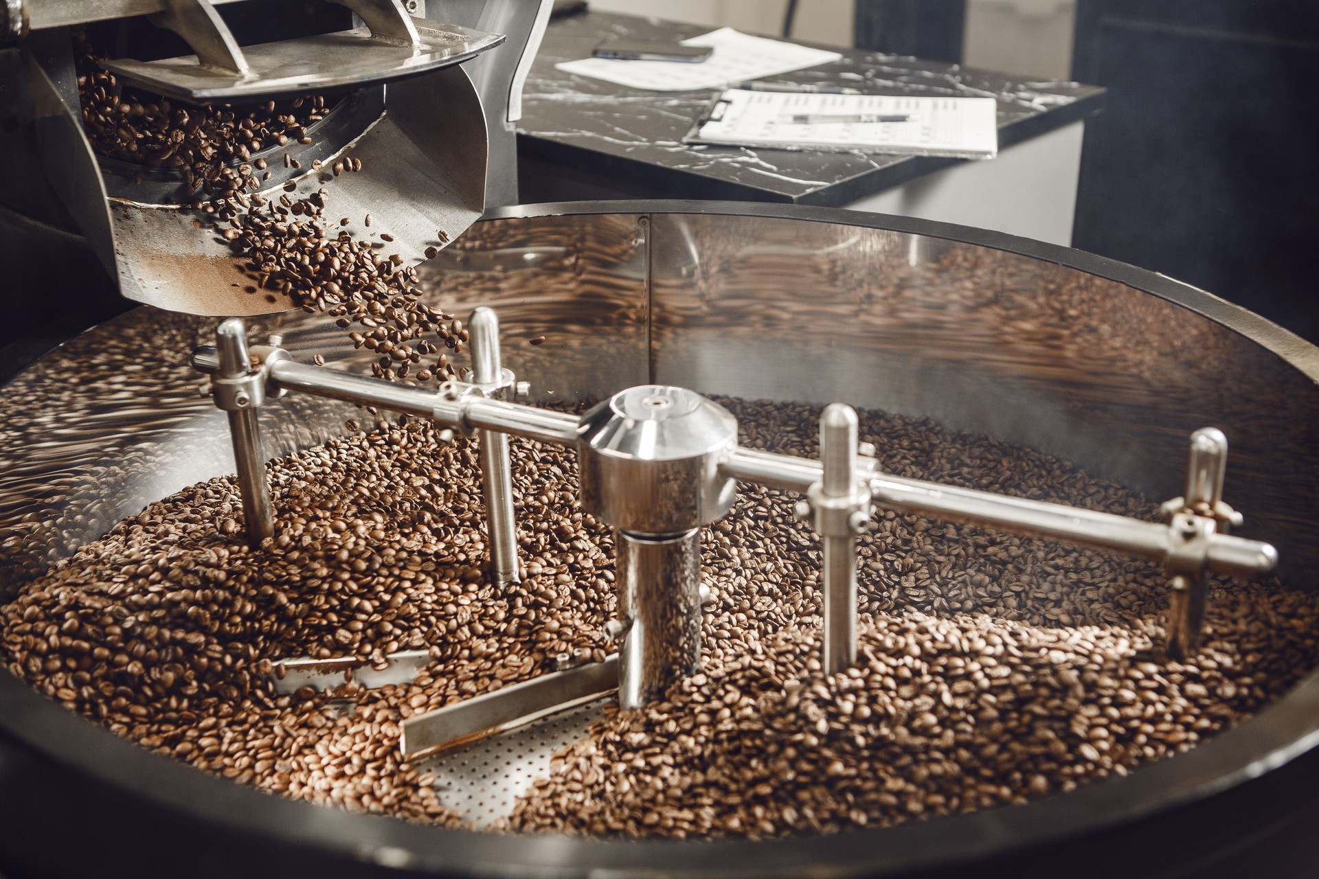 Fresh Coffee Batch Mixing Cooling in Factory Tray After Roasting Process, Showcasing Workflow in Coffee Production